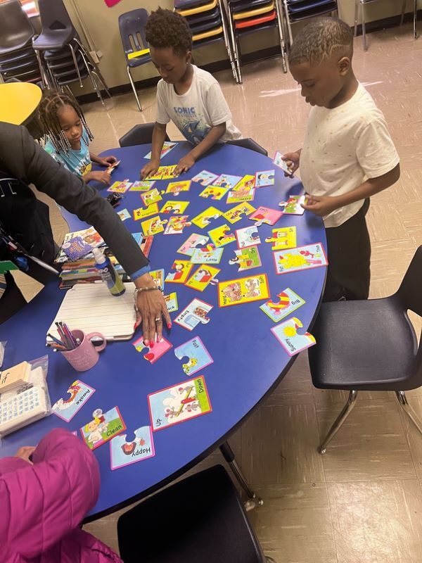 Children matching up puzzle pieces that have descriptive words on them.