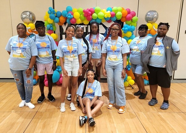 Group of young women standing and smiling for a photo.