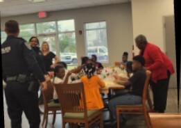 Children and adults at a table making snowglobes at the Youth Center.